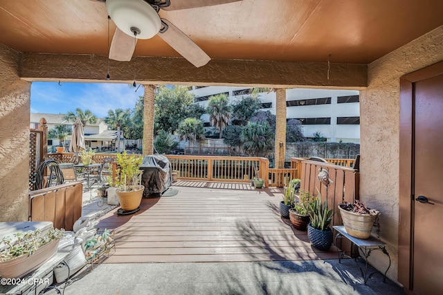 wooden deck featuring grilling area and ceiling fan