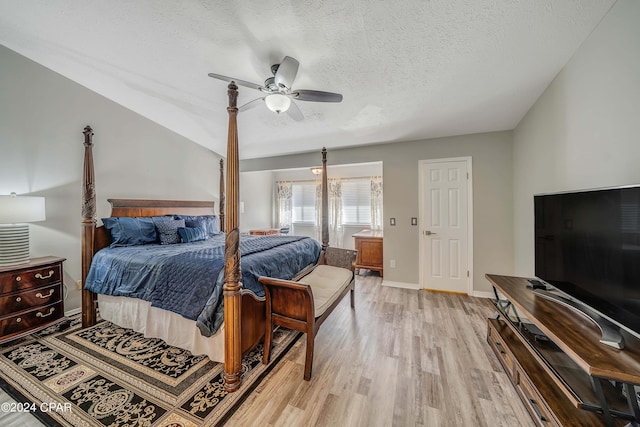 bedroom featuring ceiling fan, light hardwood / wood-style floors, and a textured ceiling