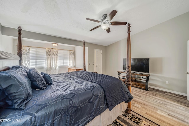 bedroom with a textured ceiling, light hardwood / wood-style flooring, and ceiling fan