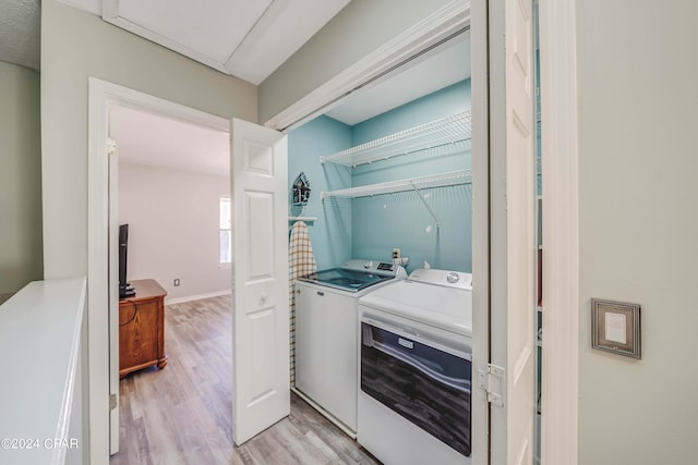 washroom featuring washer and dryer and light hardwood / wood-style floors