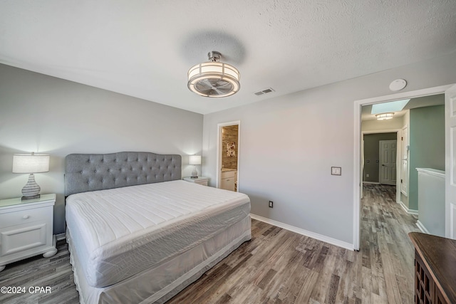 bedroom featuring wood-type flooring and a textured ceiling