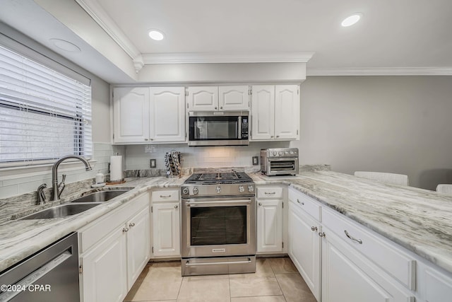 kitchen with white cabinetry, sink, tasteful backsplash, light tile patterned flooring, and appliances with stainless steel finishes