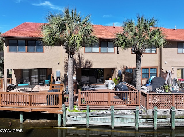 back of property with a deck with water view