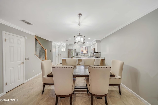 tiled dining space featuring a notable chandelier and ornamental molding