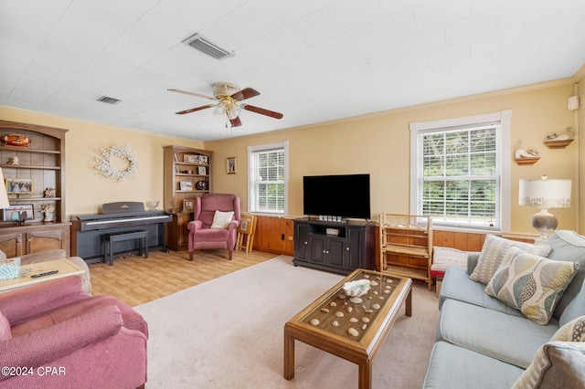 living room featuring a healthy amount of sunlight, light hardwood / wood-style floors, crown molding, and ceiling fan