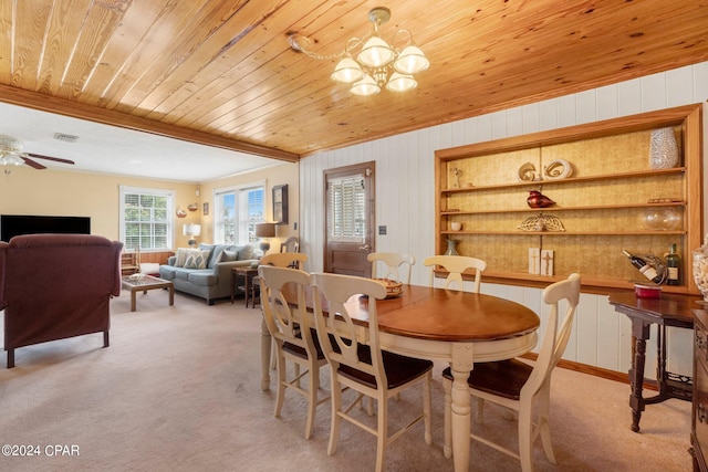 dining space featuring ceiling fan with notable chandelier, wood ceiling, wood walls, and light colored carpet