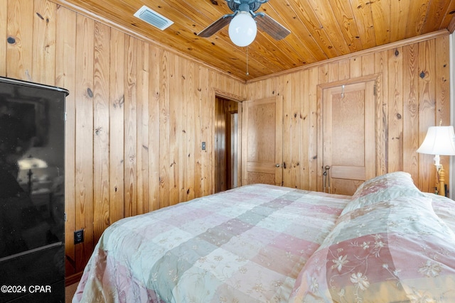 bedroom with wooden ceiling, wood walls, and ceiling fan