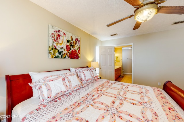 bedroom featuring a textured ceiling, ensuite bath, and ceiling fan