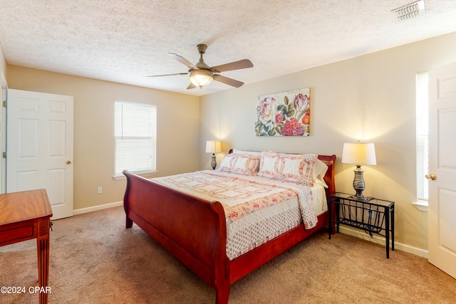 bedroom featuring carpet flooring, a textured ceiling, and ceiling fan