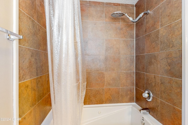 bathroom with shower / bath combo with shower curtain and a textured ceiling