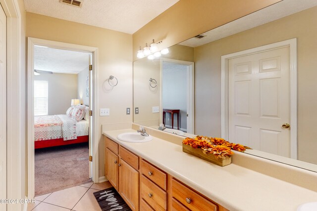 bathroom featuring a textured ceiling, vanity, and tile patterned flooring