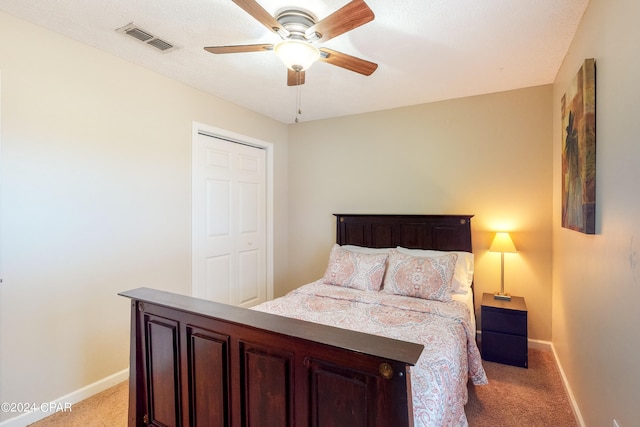 carpeted bedroom featuring ceiling fan and a closet