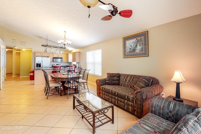 tiled living room featuring ceiling fan with notable chandelier, a textured ceiling, and lofted ceiling