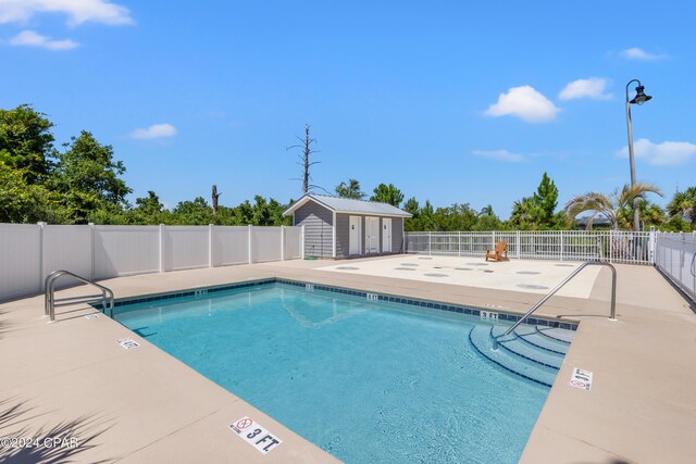 view of swimming pool with a patio and an outdoor structure