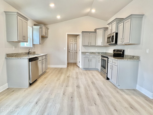 kitchen with stainless steel appliances, light hardwood / wood-style flooring, lofted ceiling, and light stone counters