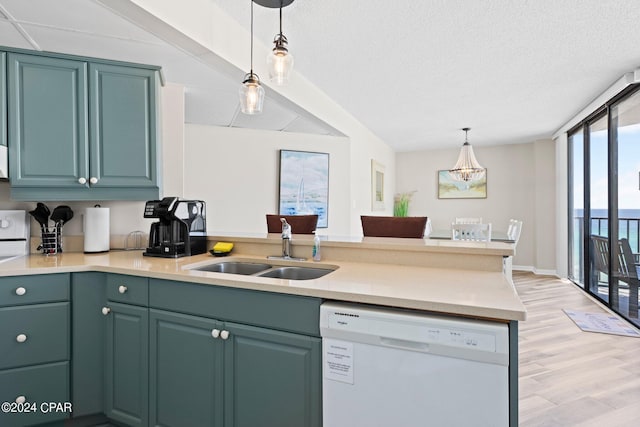 kitchen featuring pendant lighting, dishwasher, sink, kitchen peninsula, and floor to ceiling windows