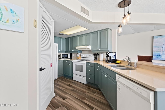 kitchen featuring dark hardwood / wood-style floors, pendant lighting, sink, white appliances, and a textured ceiling