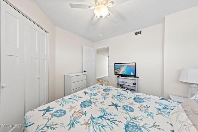 bedroom featuring a textured ceiling, ceiling fan, and a closet