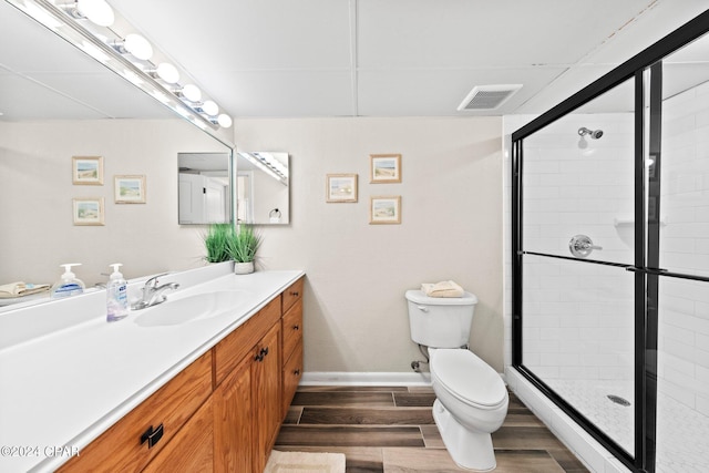 bathroom with an enclosed shower, vanity, and toilet