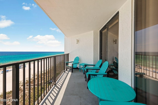 balcony featuring a water view and a beach view