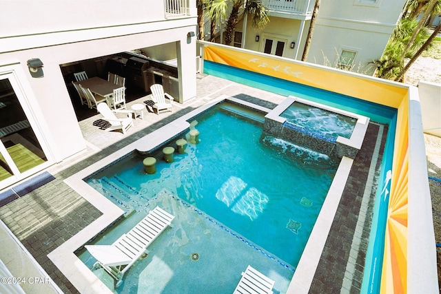 view of pool featuring a patio and an in ground hot tub