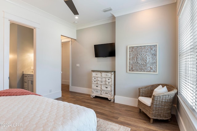 bedroom featuring ensuite bathroom, dark hardwood / wood-style flooring, ornamental molding, and ceiling fan