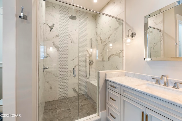 bathroom featuring a shower with shower door and vanity