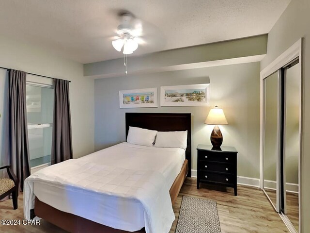 bedroom featuring ceiling fan, light hardwood / wood-style floors, and a closet