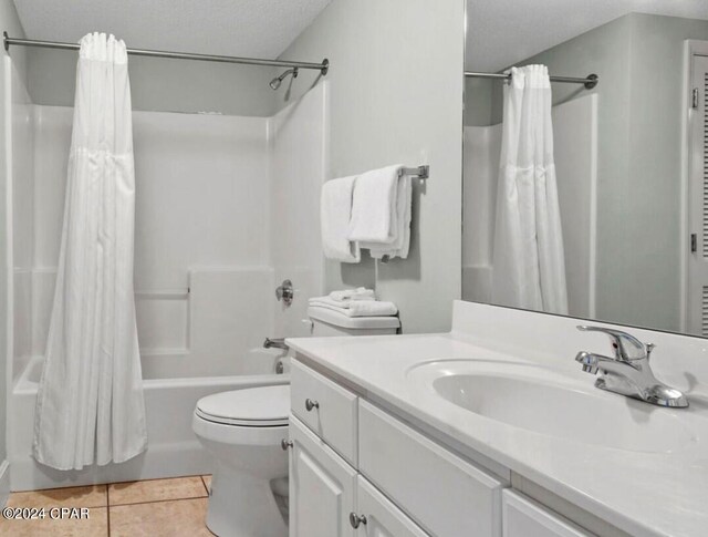 full bathroom featuring tile patterned flooring, vanity, a textured ceiling, toilet, and shower / bath combo with shower curtain