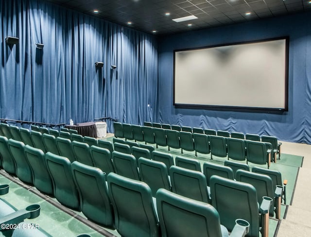 carpeted home theater featuring a drop ceiling