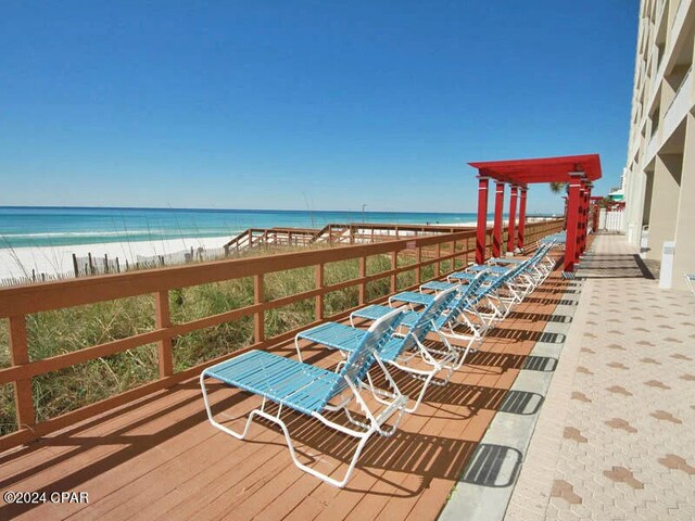 balcony featuring a view of the beach and a deck with water view