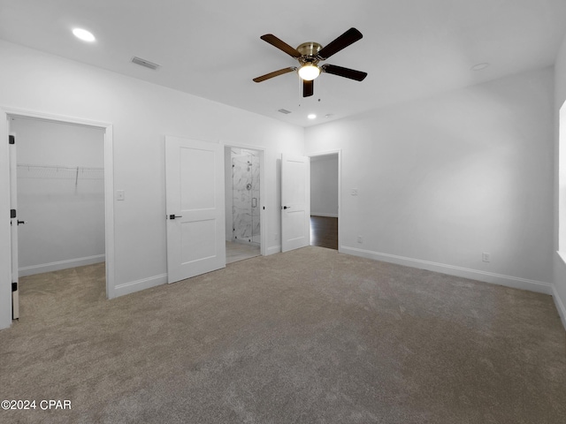 unfurnished bedroom featuring baseboards, visible vents, a walk in closet, and carpet flooring