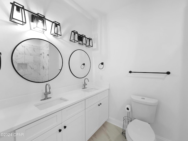 bathroom featuring marble finish floor, a sink, toilet, and double vanity