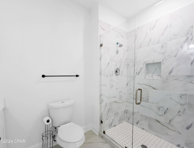 bathroom featuring toilet, marble finish floor, a shower stall, and baseboards