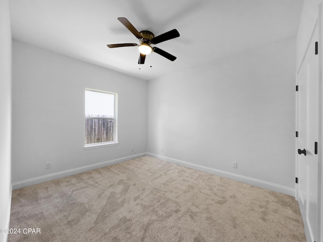 carpeted empty room with ceiling fan and baseboards