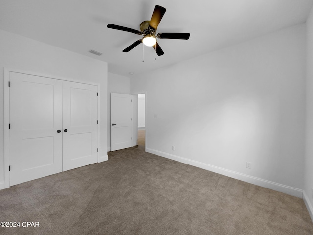 unfurnished bedroom featuring baseboards, visible vents, ceiling fan, carpet flooring, and a closet