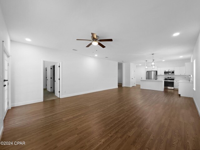 unfurnished living room with hardwood / wood-style flooring, sink, and ceiling fan