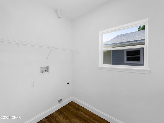 clothes washing area with dark wood-style flooring, hookup for a washing machine, hookup for an electric dryer, laundry area, and baseboards