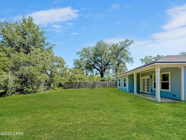 view of yard featuring french doors and fence