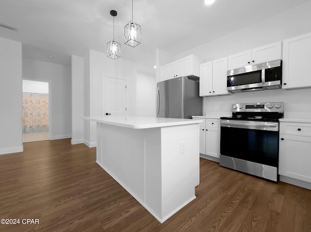 kitchen featuring decorative light fixtures, white cabinets, a center island, appliances with stainless steel finishes, and dark wood-type flooring