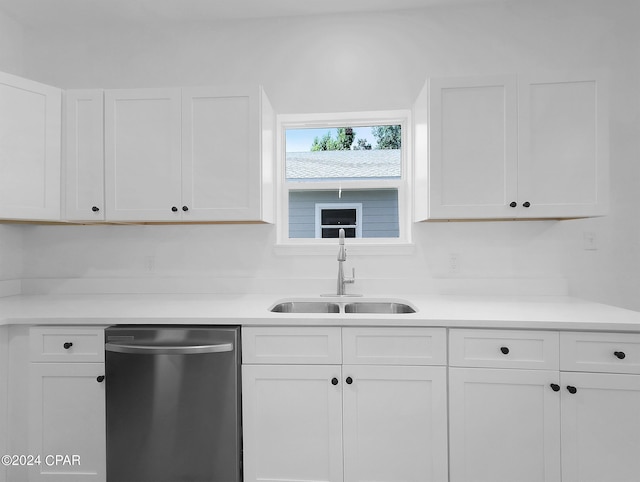 kitchen with light countertops, stainless steel dishwasher, a sink, and white cabinets