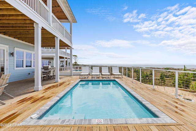 view of swimming pool featuring a deck with water view