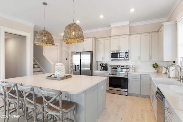 kitchen featuring a center island, sink, hanging light fixtures, stainless steel appliances, and tasteful backsplash