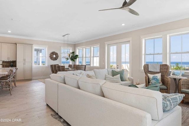 living room featuring ceiling fan, light hardwood / wood-style flooring, a water view, and ornamental molding