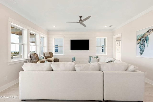 living room with ceiling fan, light wood-type flooring, and ornamental molding