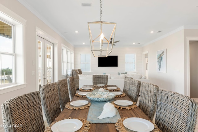 dining area with a chandelier, french doors, and crown molding