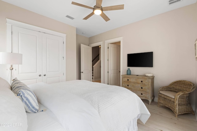 bedroom with light wood-type flooring, a closet, and ceiling fan