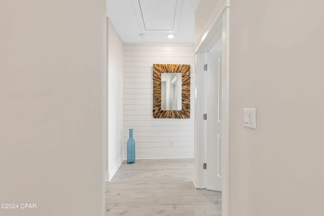 corridor featuring wooden walls and light hardwood / wood-style flooring