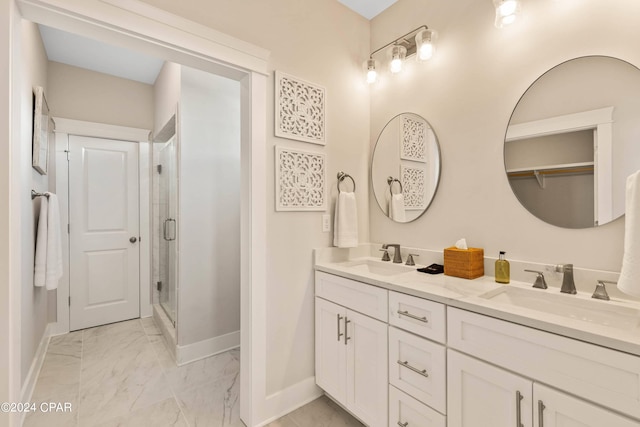 bathroom featuring a shower with door and vanity