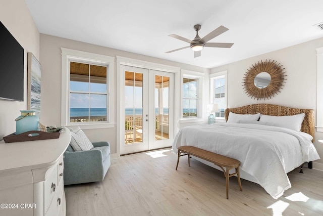 bedroom featuring french doors, access to outside, ceiling fan, a water view, and multiple windows